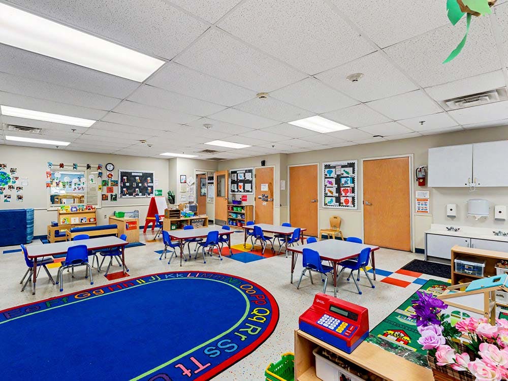 Empty colorful children's classroom with small tables and chairs