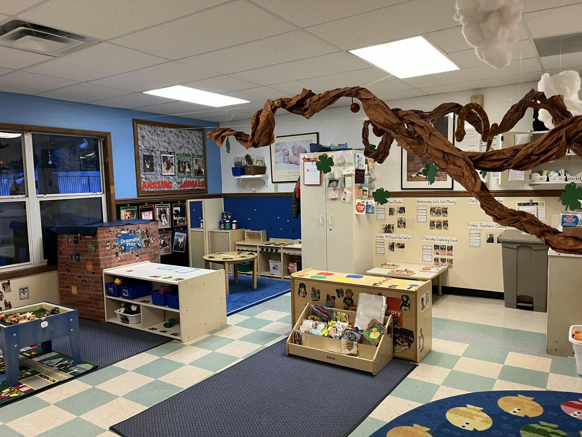 An empty early childhood classroom with various play areas and learning centers