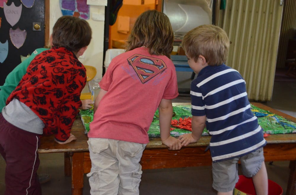 Three children looking at something on a table