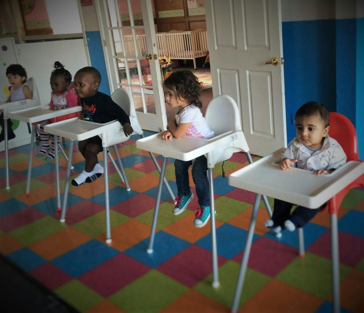 Four children sitting in high chairs