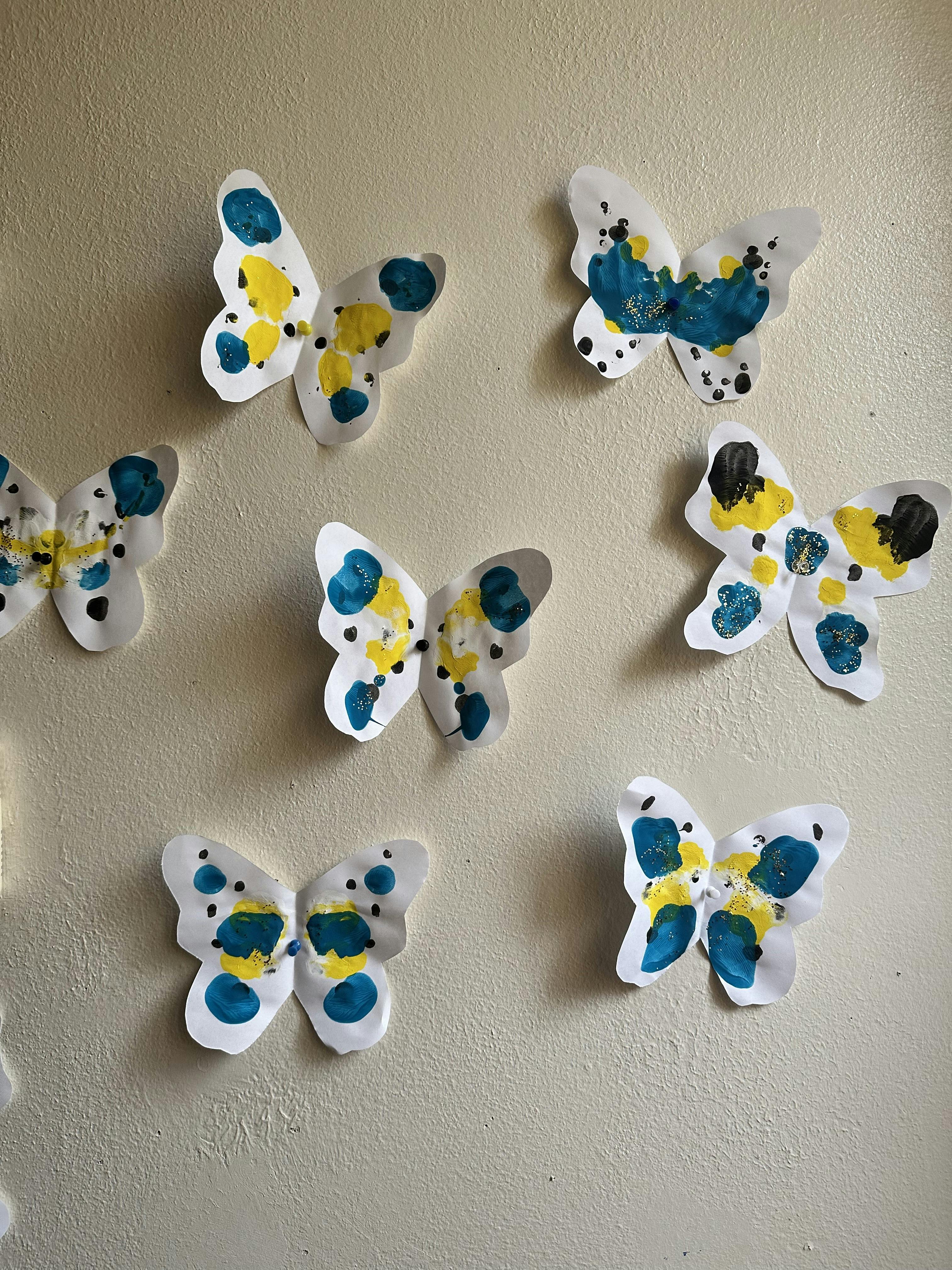 Crafted paper butterflies with yellow and blue paint spots