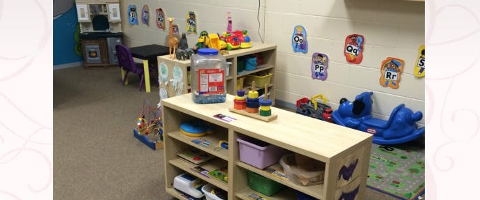 Playroom with shelves of toys and a blue rocking toy