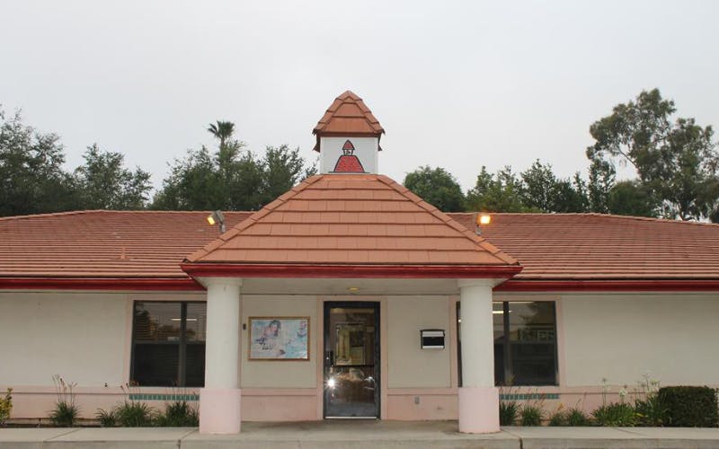Entrance of a building with a red-tiled roof and a small decorative tower