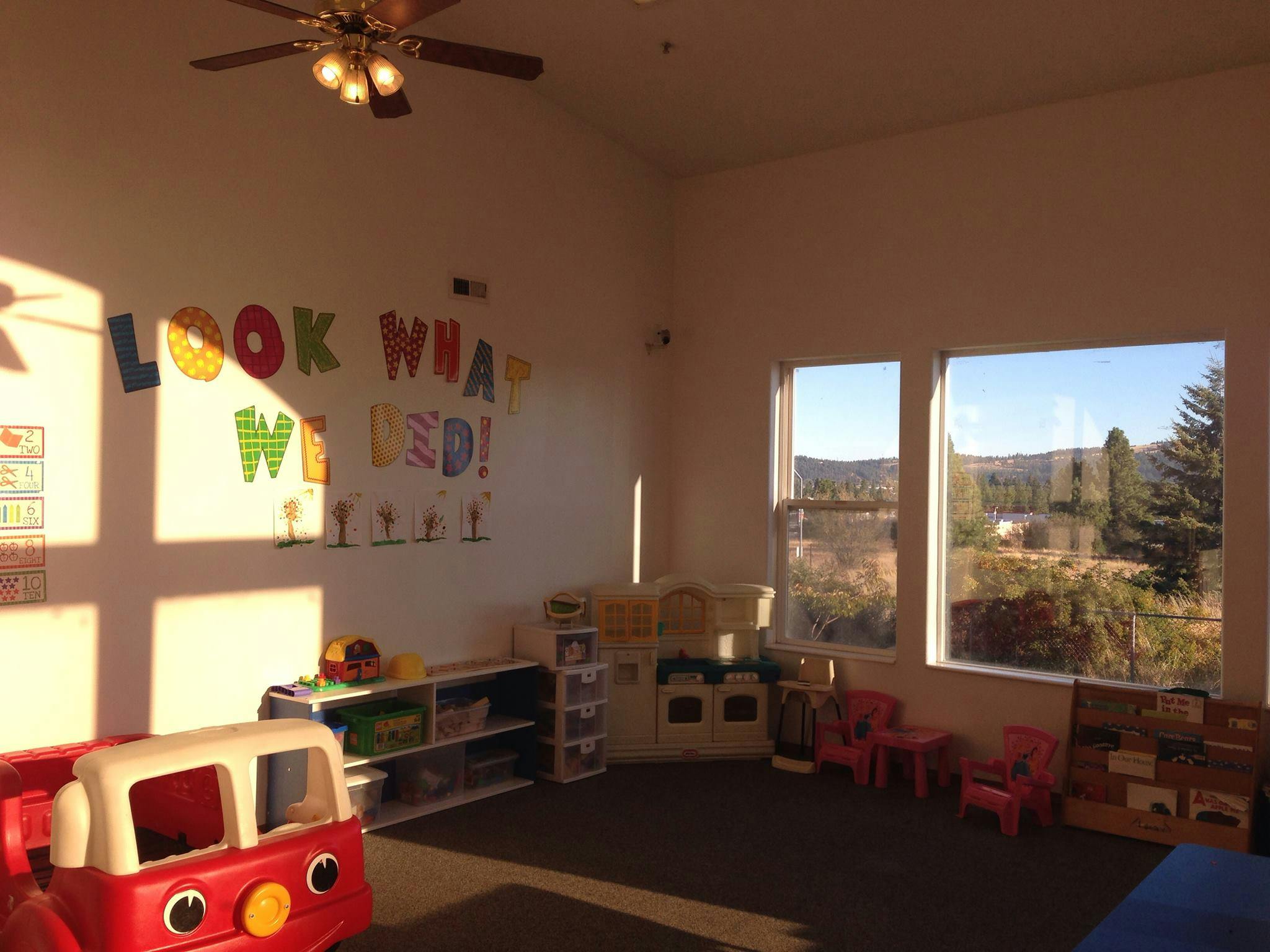 Playroom with toy fire truck, shelves, and windows overlooking a landscape