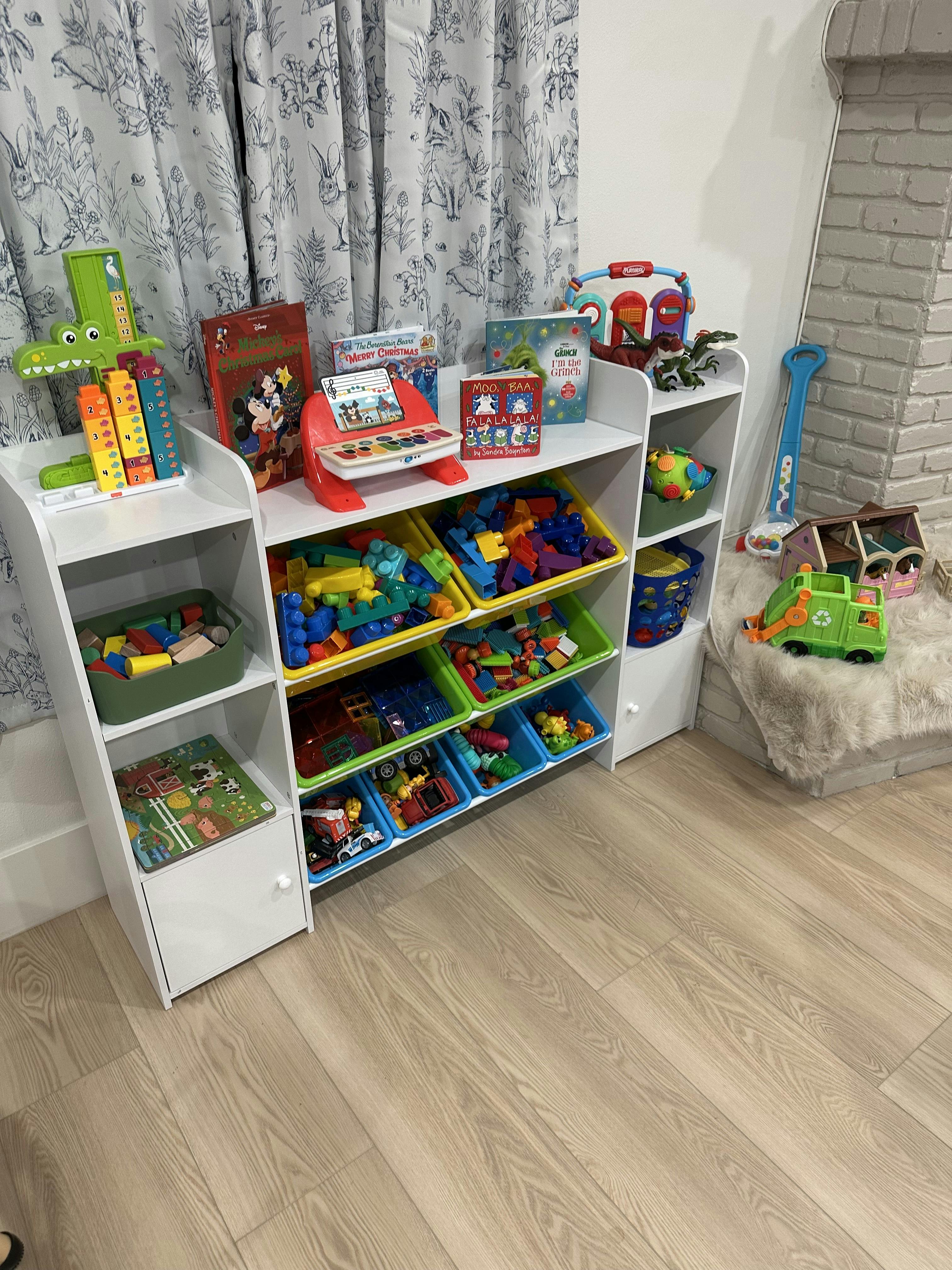 white toy storage organizer with colorful bins and various toys and books