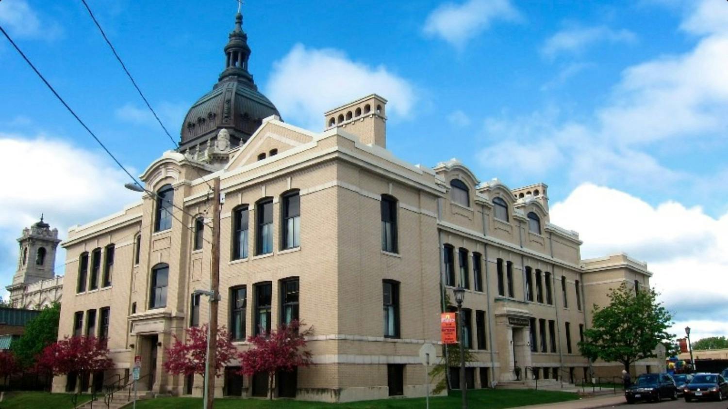 Large multi-story historic building with a domed roof and brick facade