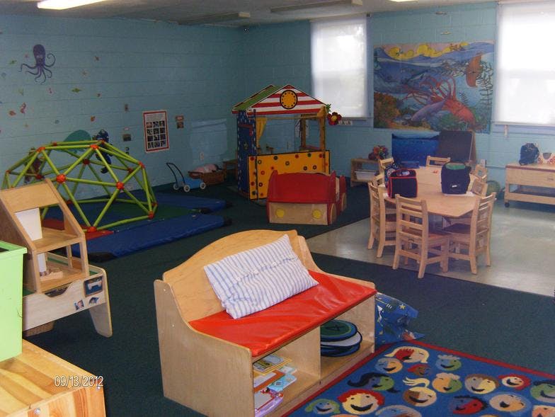 Playroom with a climbing dome, playhouse, and small table with chairs