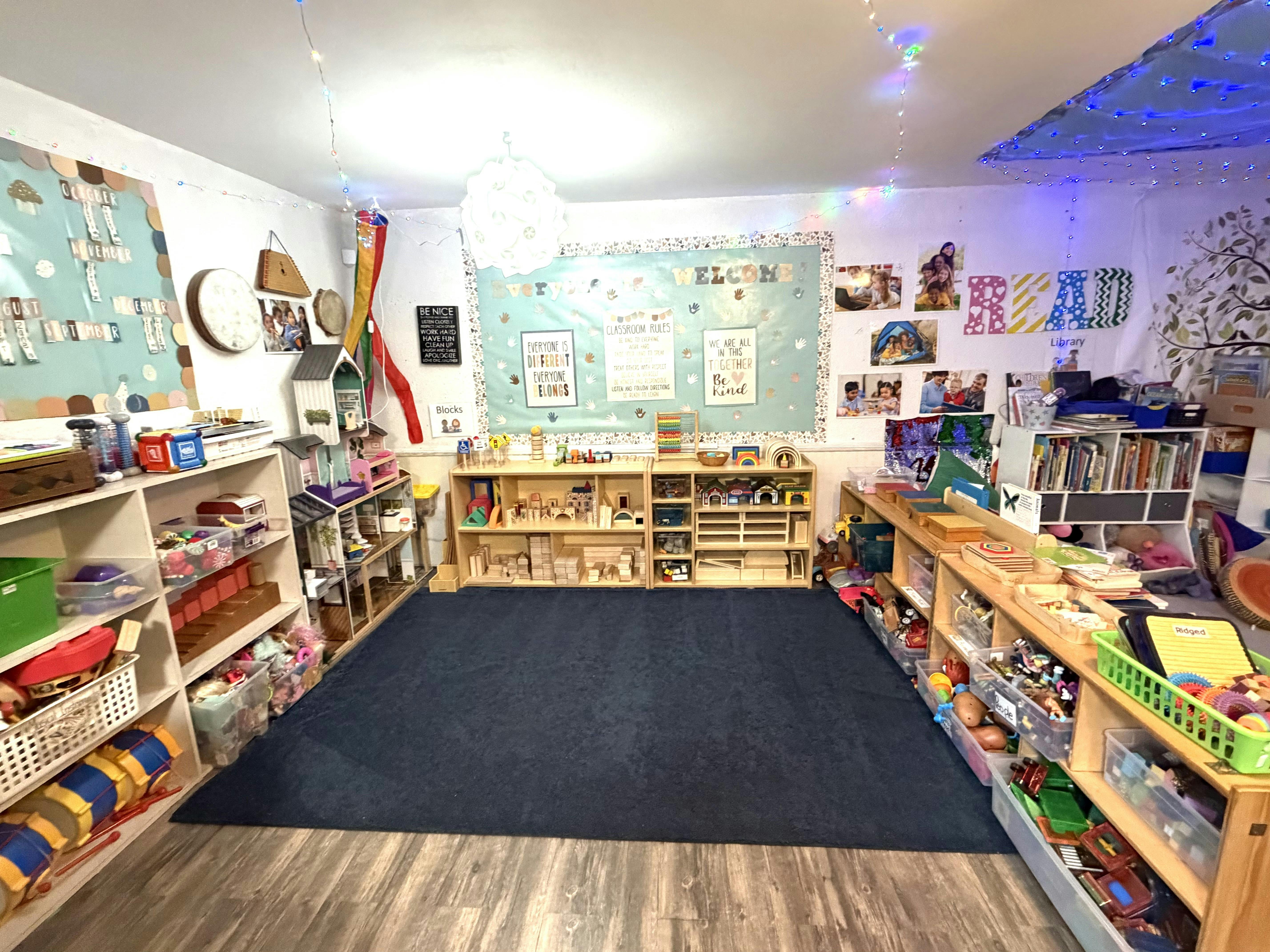 Classroom filled with learning materials, shelves of toys, and educational signs