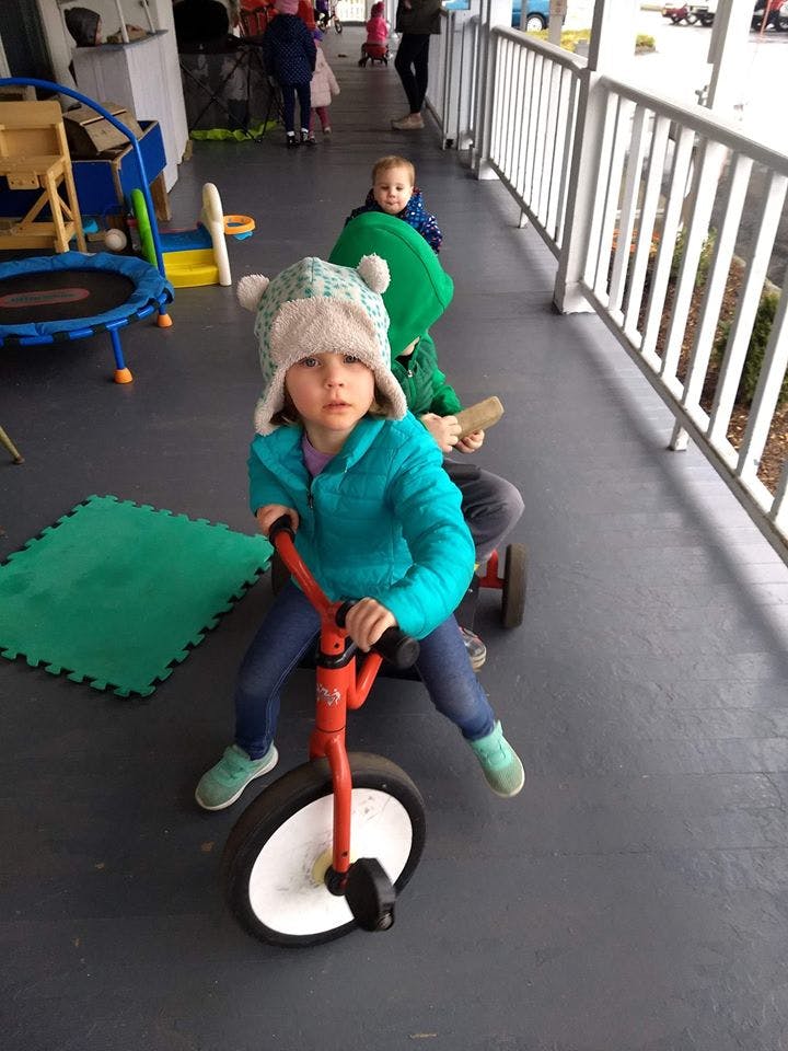 Child in a hat riding a tricycle