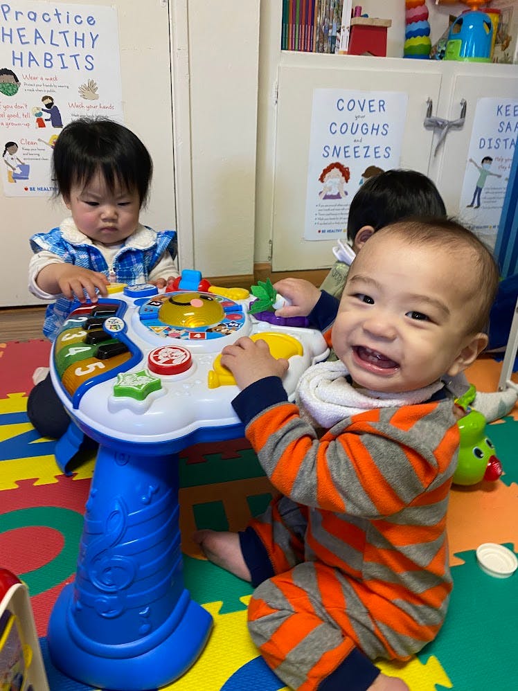 Two children playing with a toy activity table