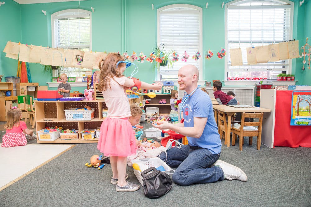 Adult and child playing together in a classroom