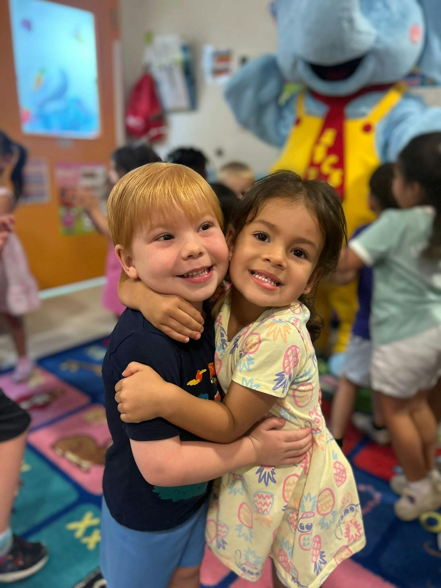 Two children hugging in a classroom
