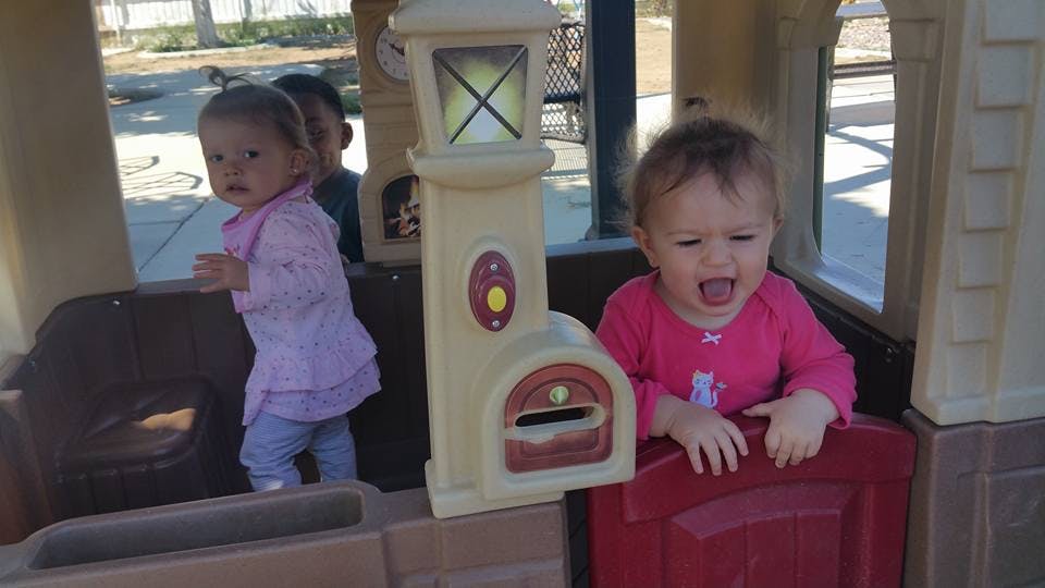 Two children playing in a toy house