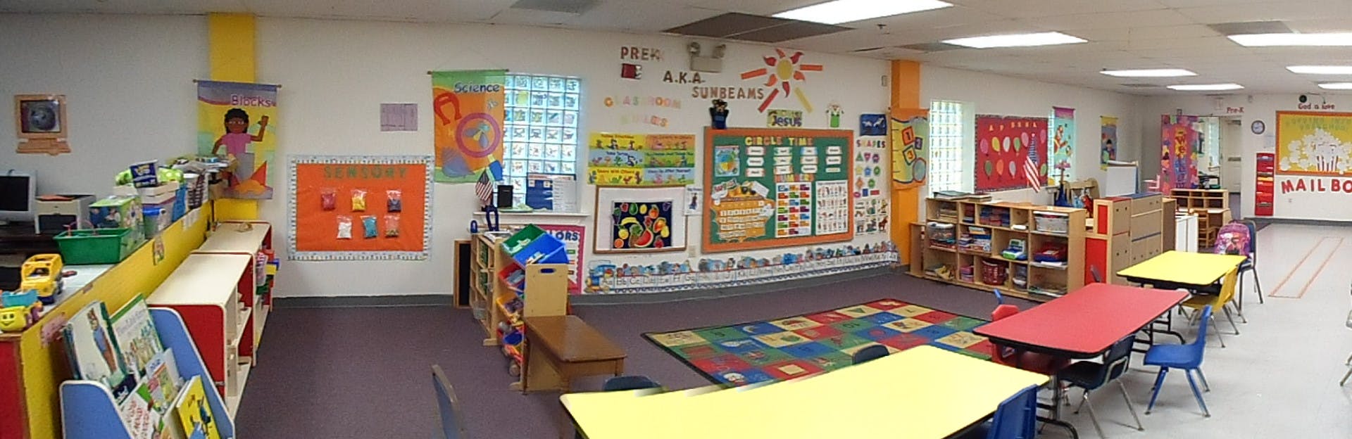 Classroom with colorful decorations, tables, and a play area