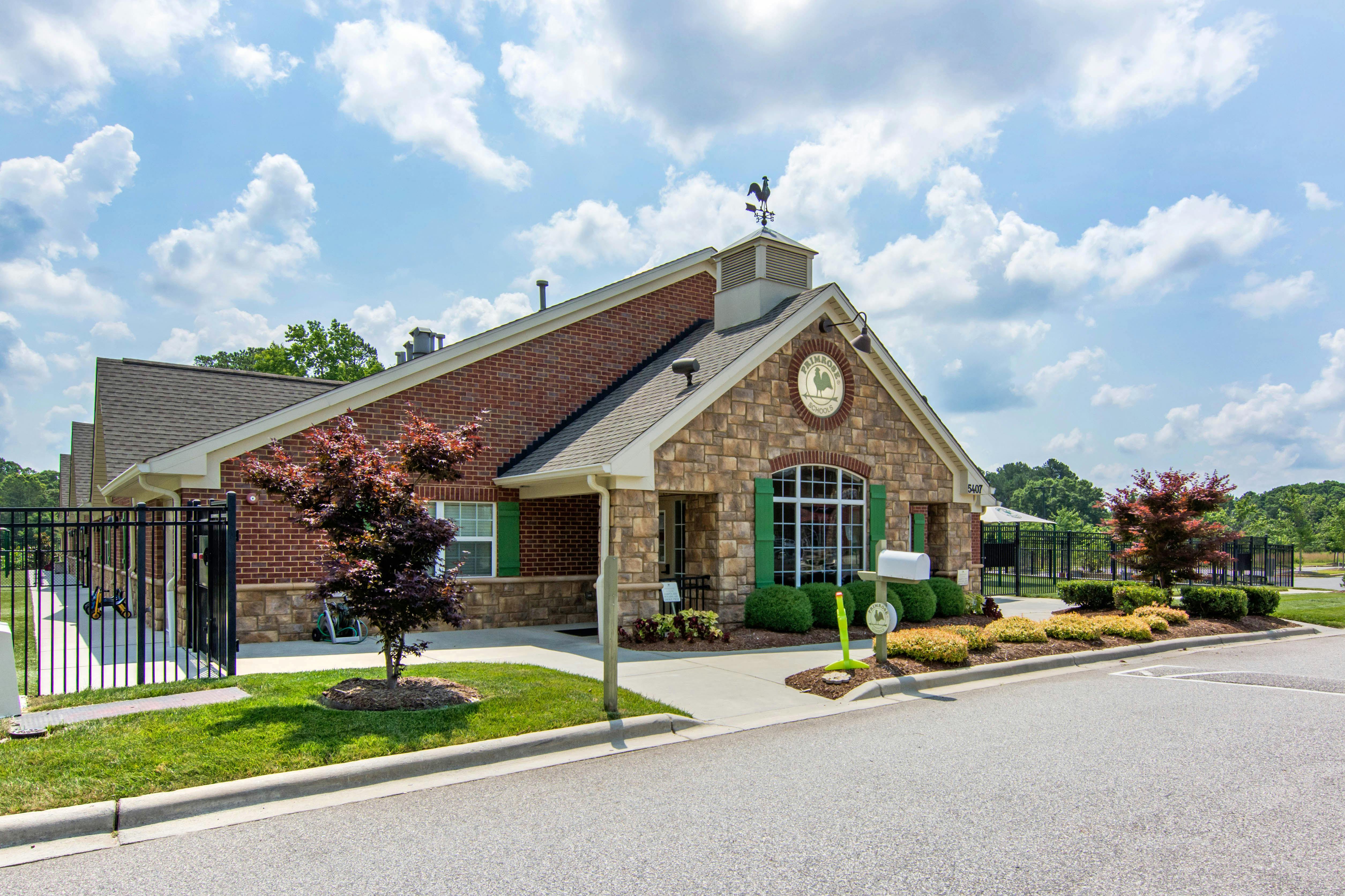 Building with brick and stone facade, green shutters, and a weathervane