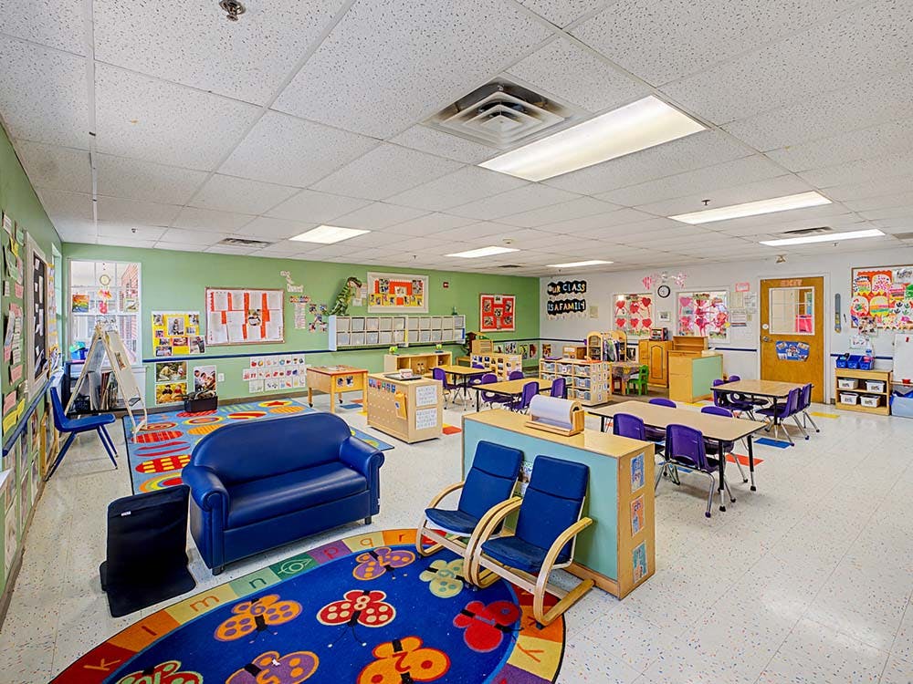 Classroom with child-sized furniture and colorful rugs