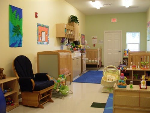 Nursery room with cribs, a rocking chair, and baby play items