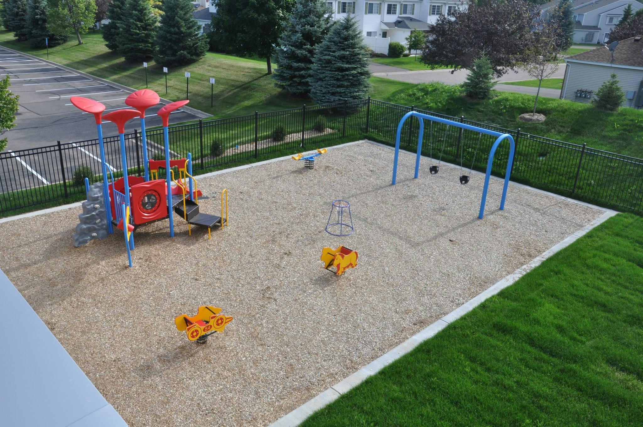 Playground with play structure, swings, and spring riders