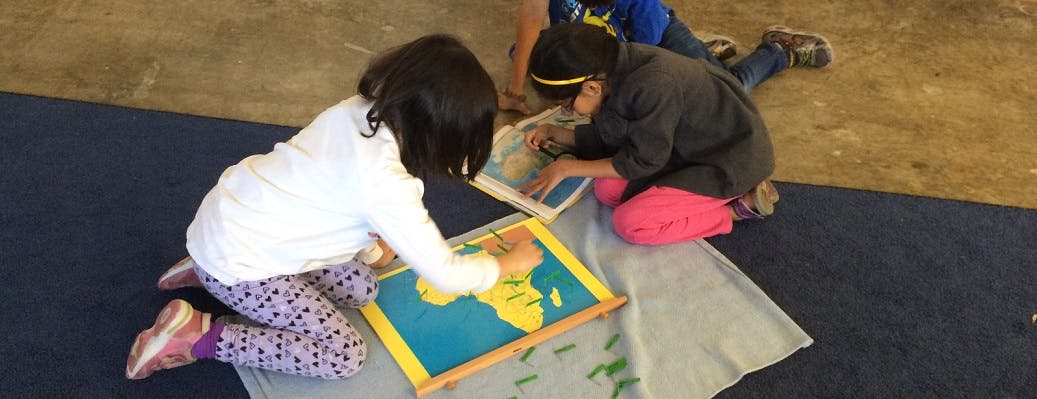 Children on floor working with puzzle maps