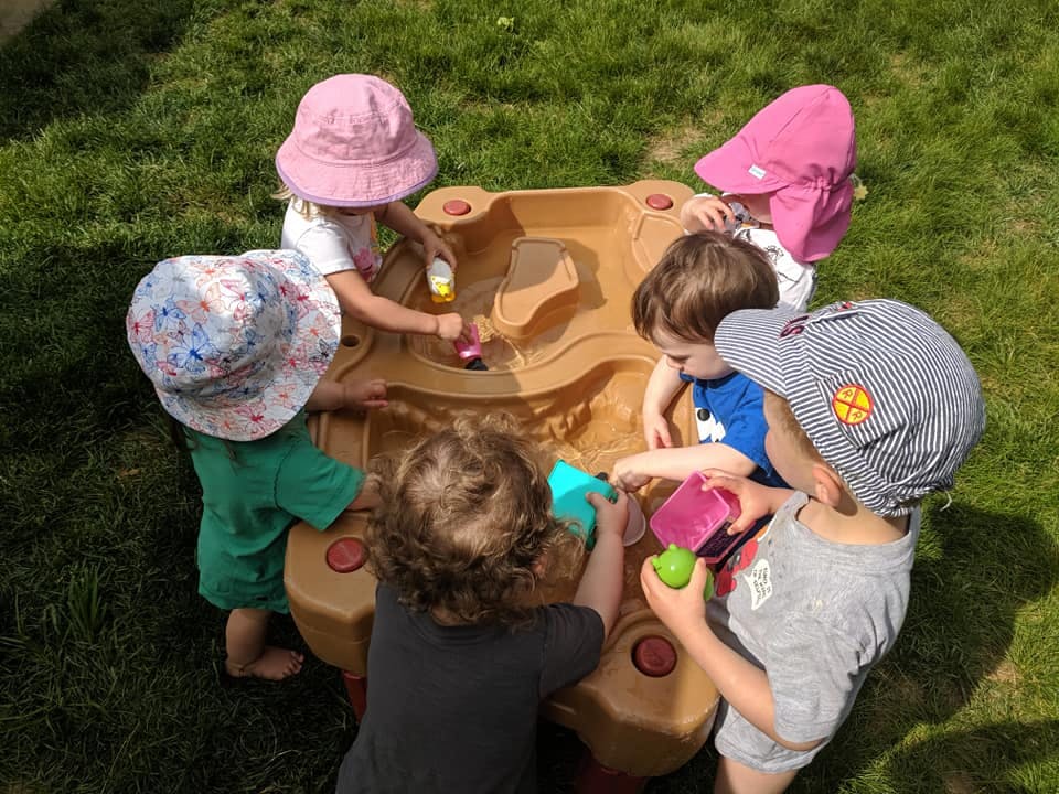 Children playing with a water table outdoors