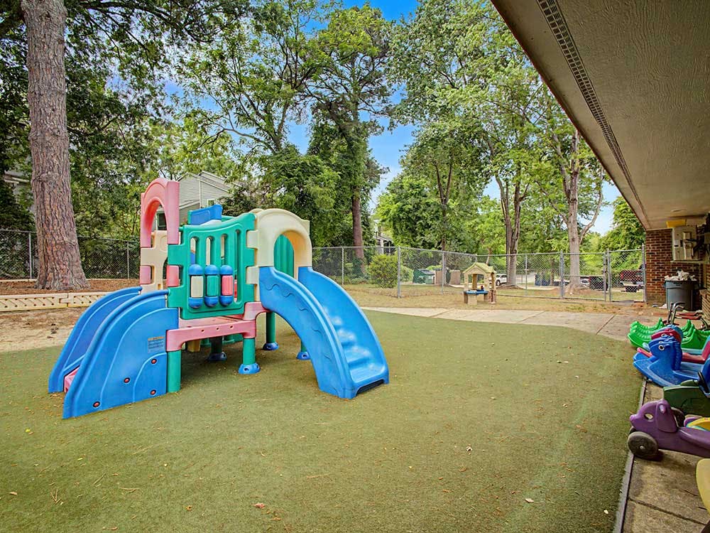 Colorful playground structure with slides on artificial turf