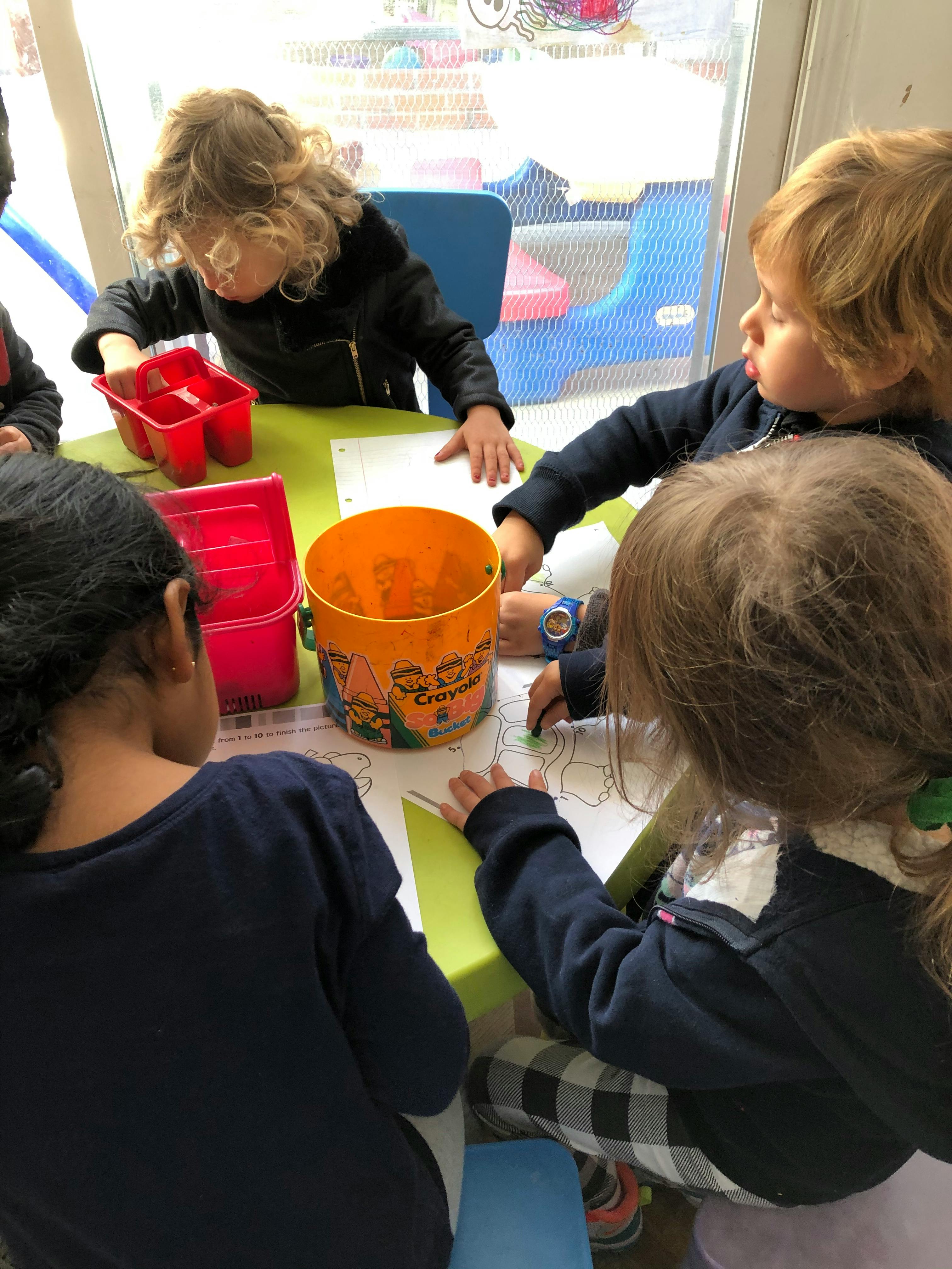 Children drawing at a table in a classroom