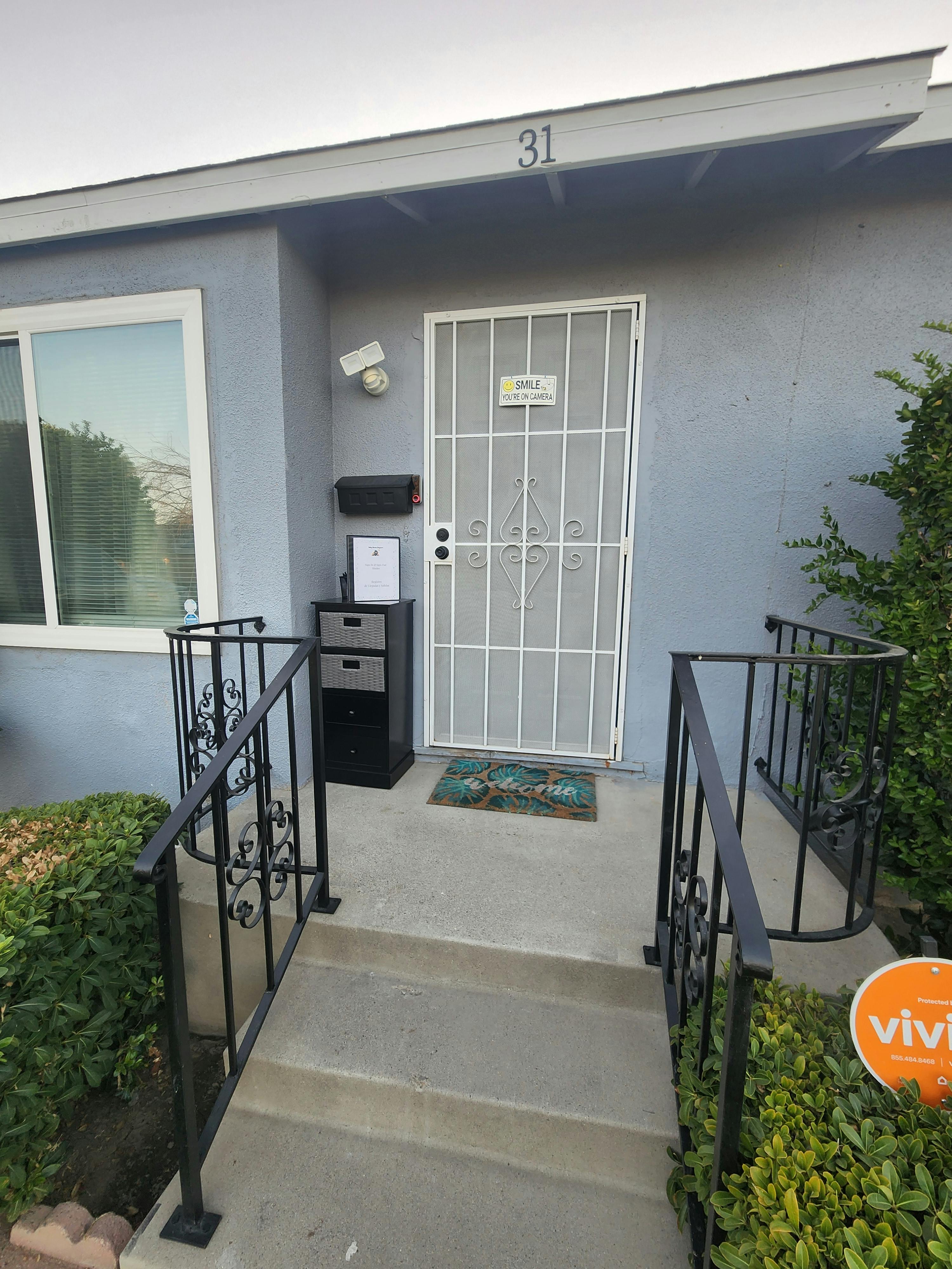 Front entrance of a building with a security door and railings
