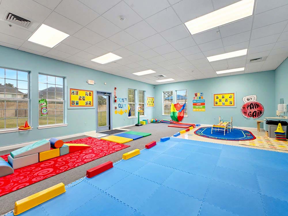 Colorful therapy gym with various soft play equipment and exercise equipment