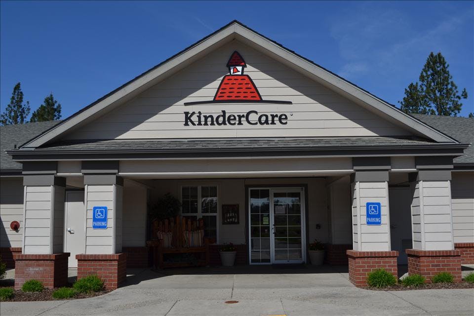 Entrance to a KinderCare building with a red and white steeple logo