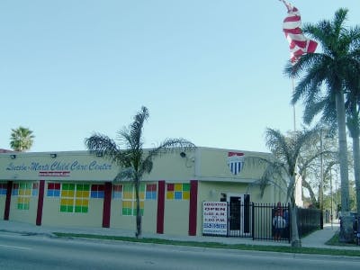 Building with sign "Little World Child Care Center" and colorful windows