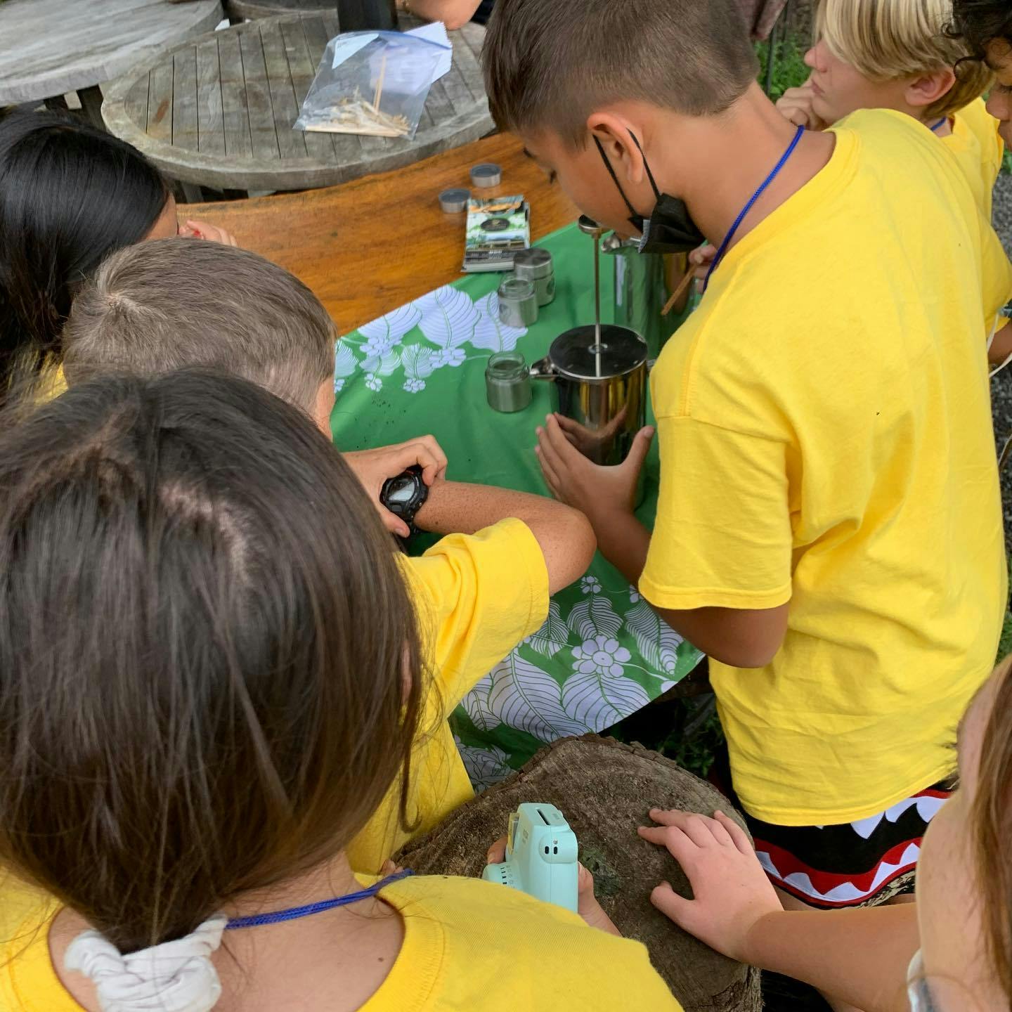 Children gathered around a table with scientific equipment