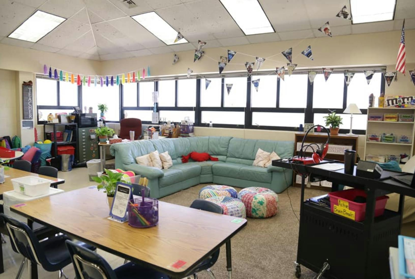 Classroom with a large sectional sofa, tables, and chairs