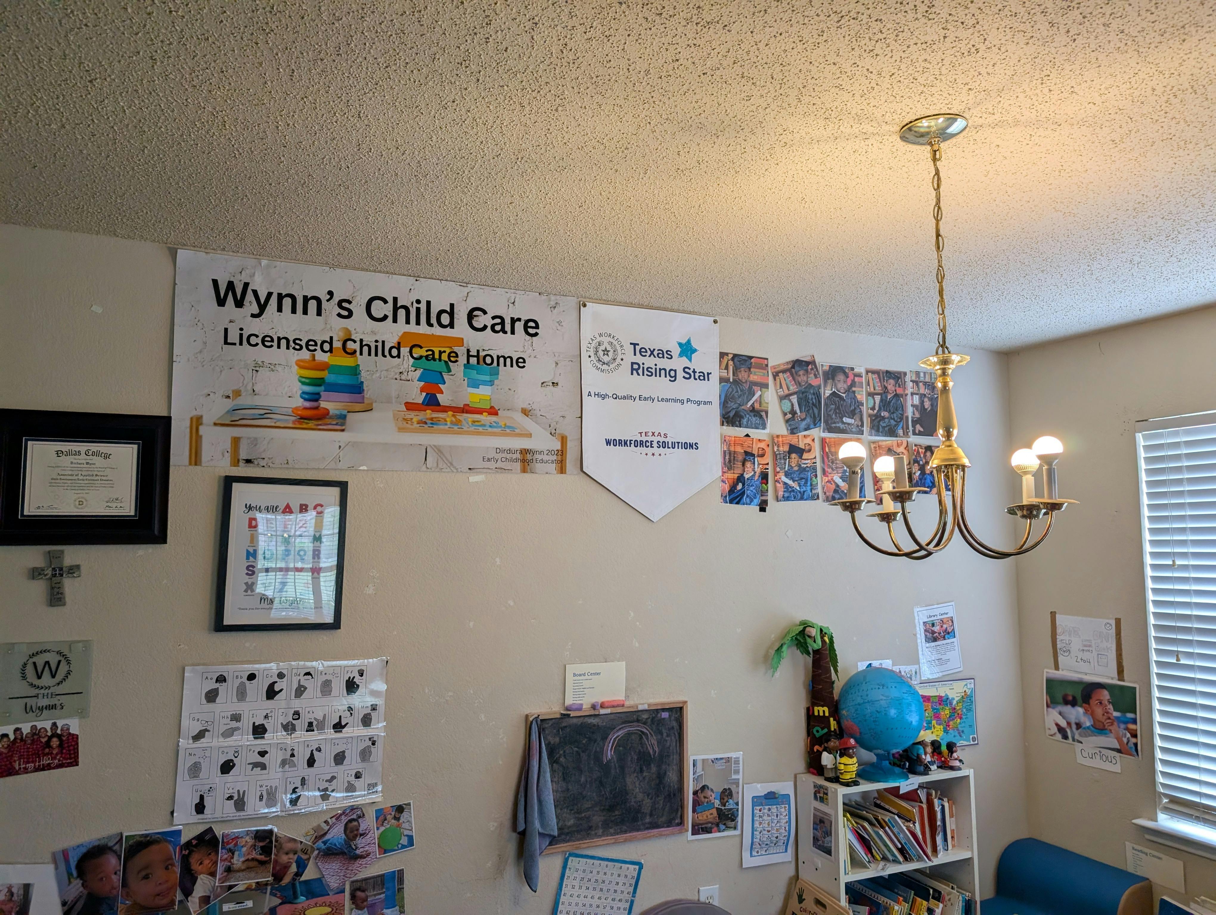 Room with various child care decor, a chandelier, and a sign for Wynn's Child Care