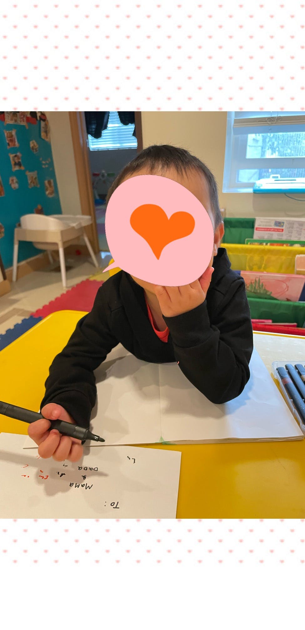 Child writing on paper with a pen