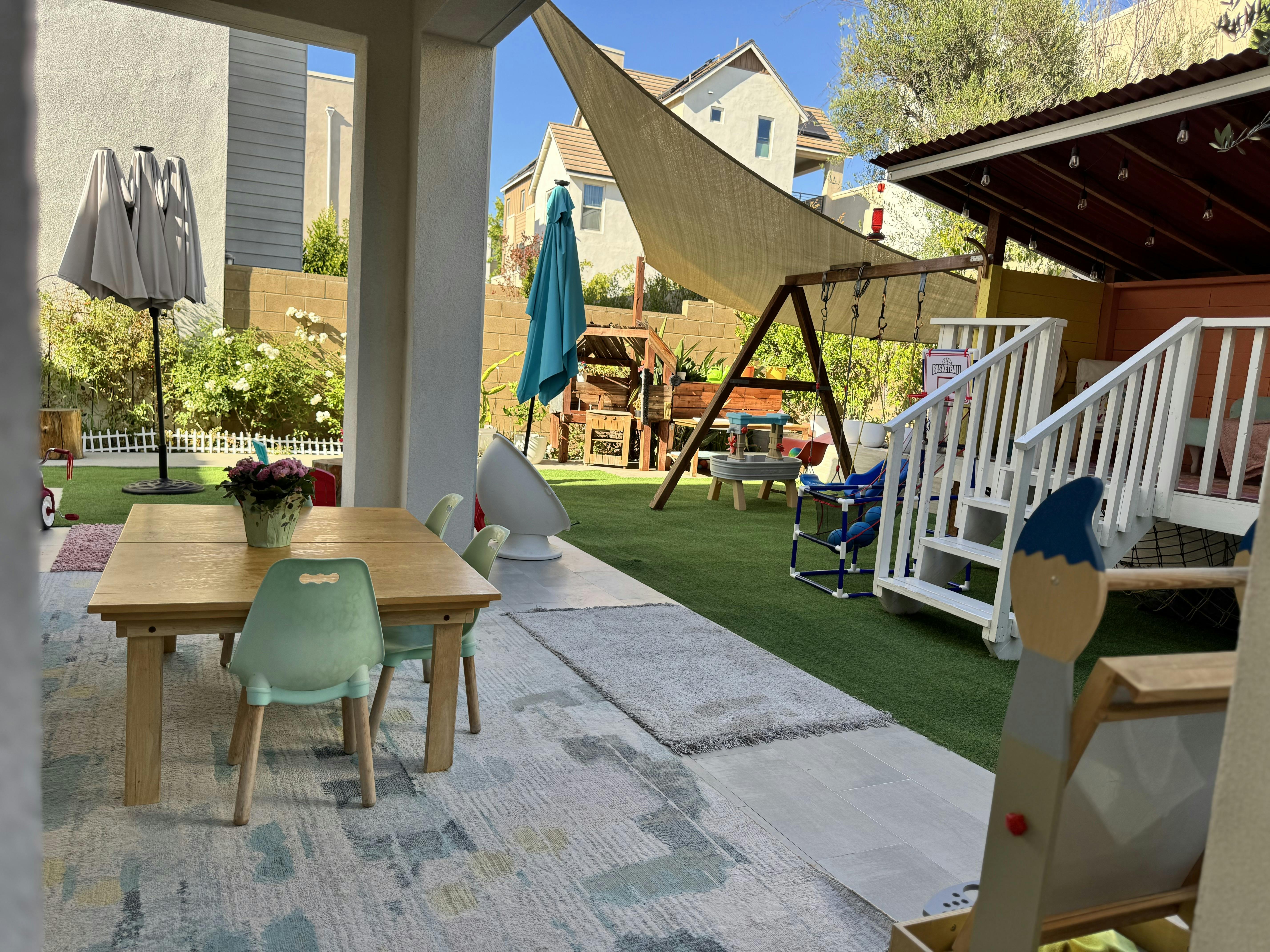 Children furniture set on a patio with a backyard play area