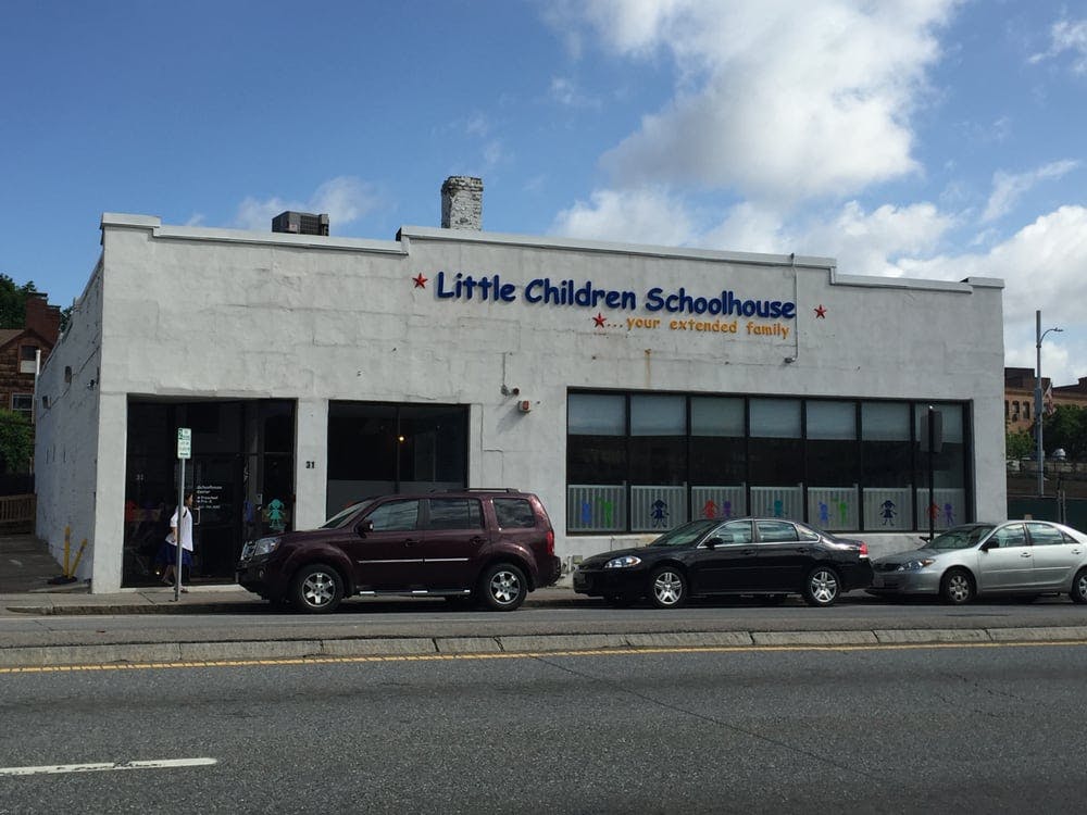 Little Children Schoolhouse building with cars parked in front