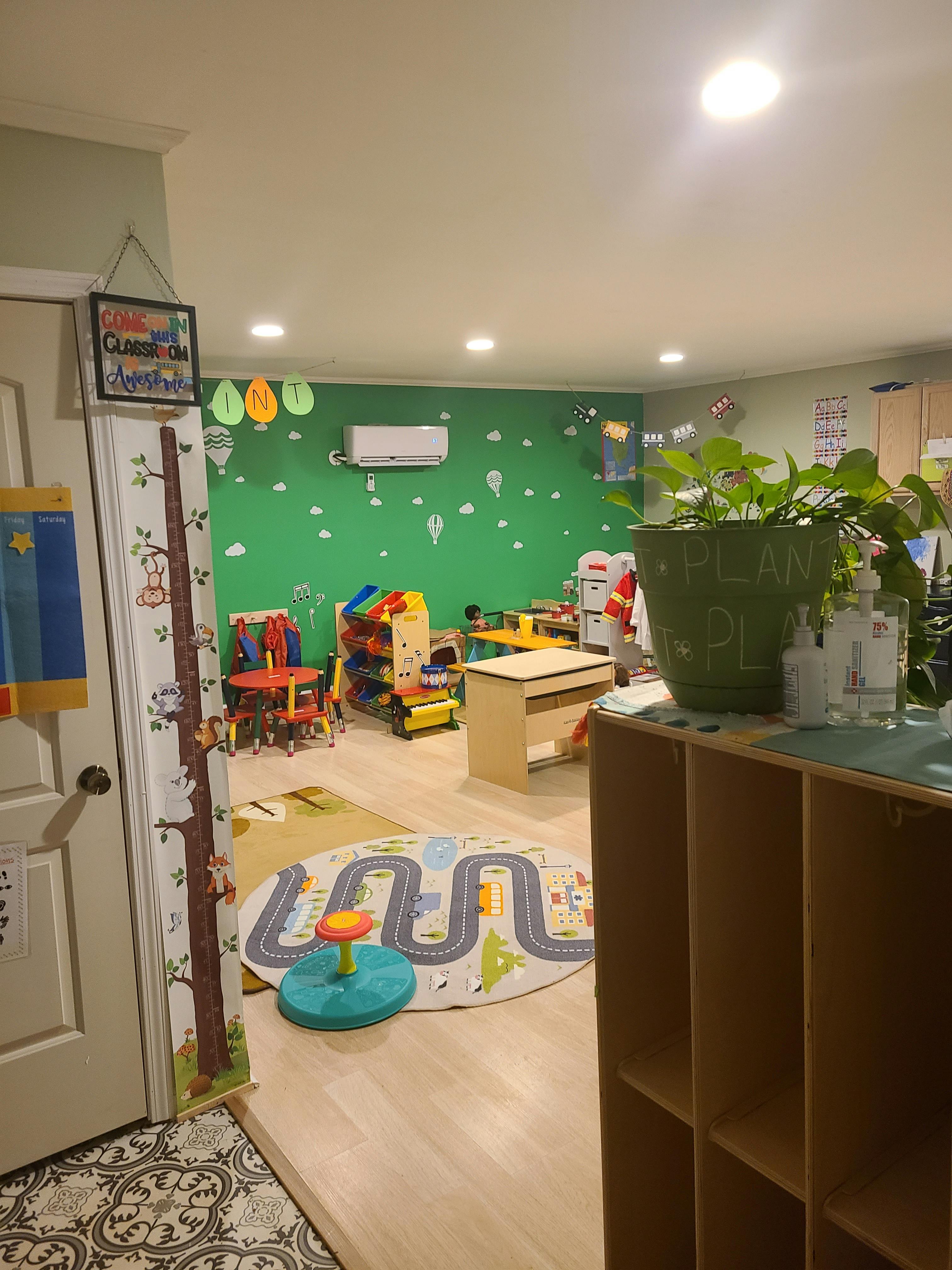 Playroom with green wall, toys, and a road-patterned rug