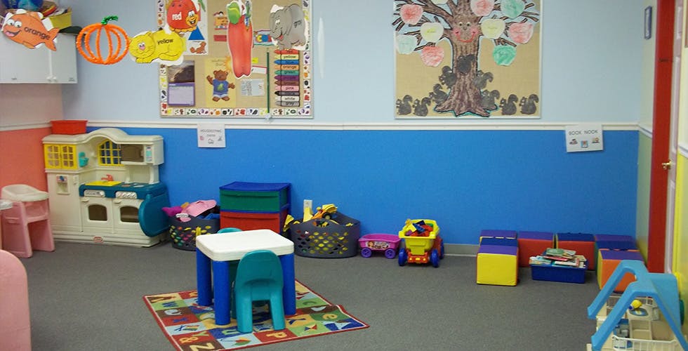 Playroom with small table and chairs, toy kitchen, and colorful decorations