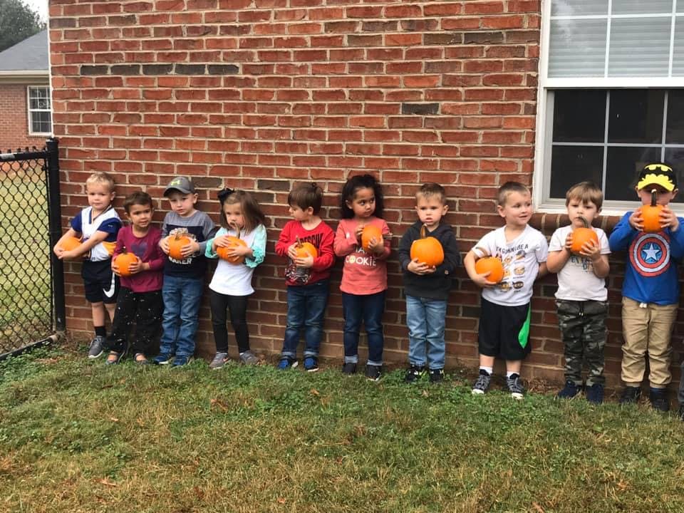 Group of children holding small pumpkins