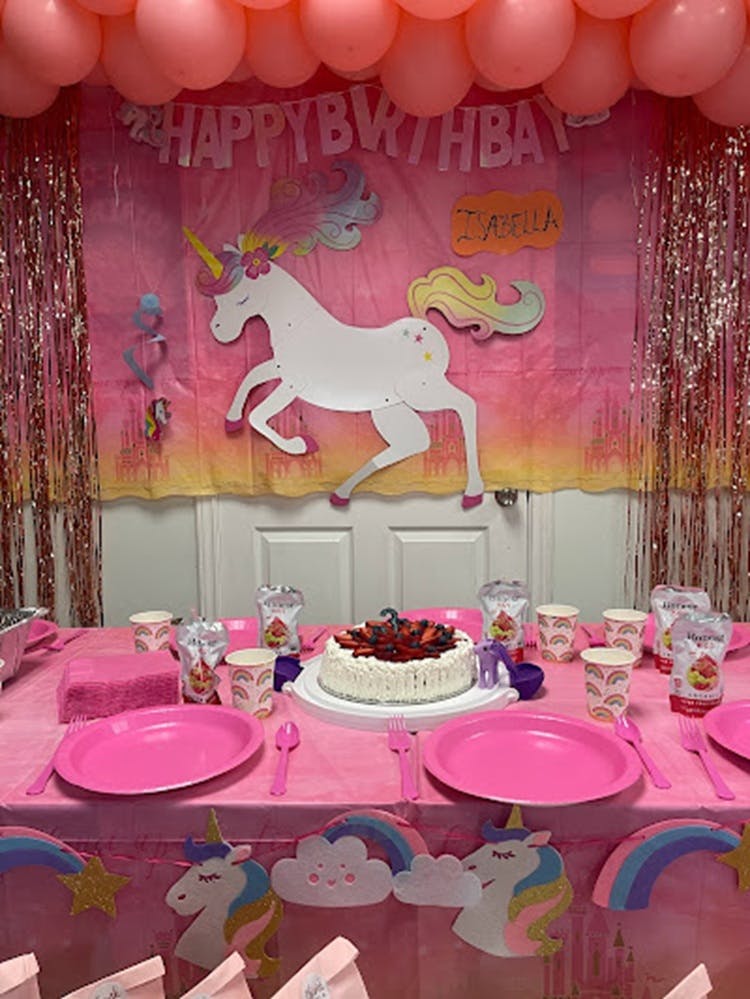 Birthday party table with unicorn decorations and cake