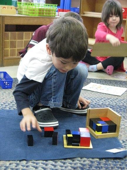 Child playing with colorful blocks on a blue mat