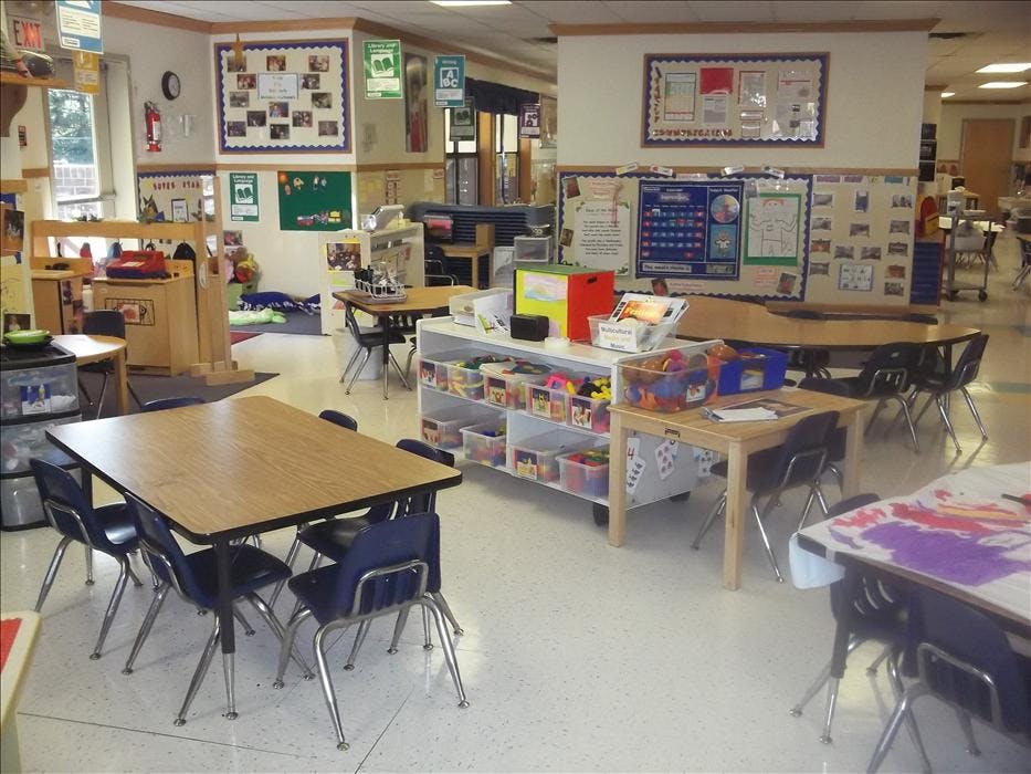 Classroom with tables, chairs, and shelves