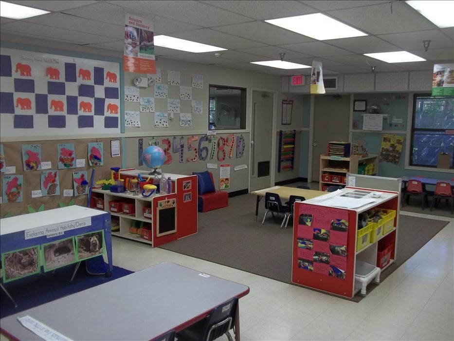 Classroom with child-sized furniture and colorful educational displays on the walls
