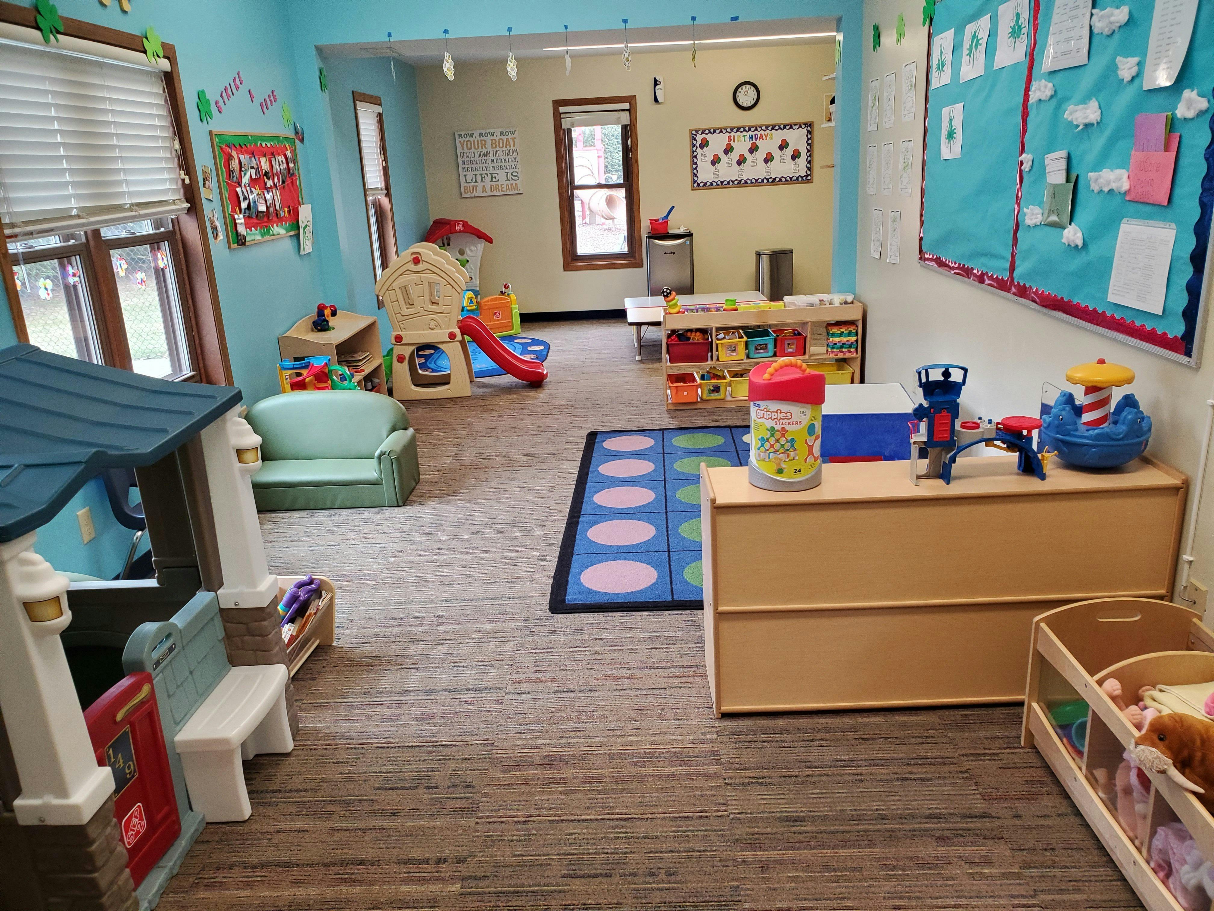 Playroom with various toys, small furniture, and a blue rug