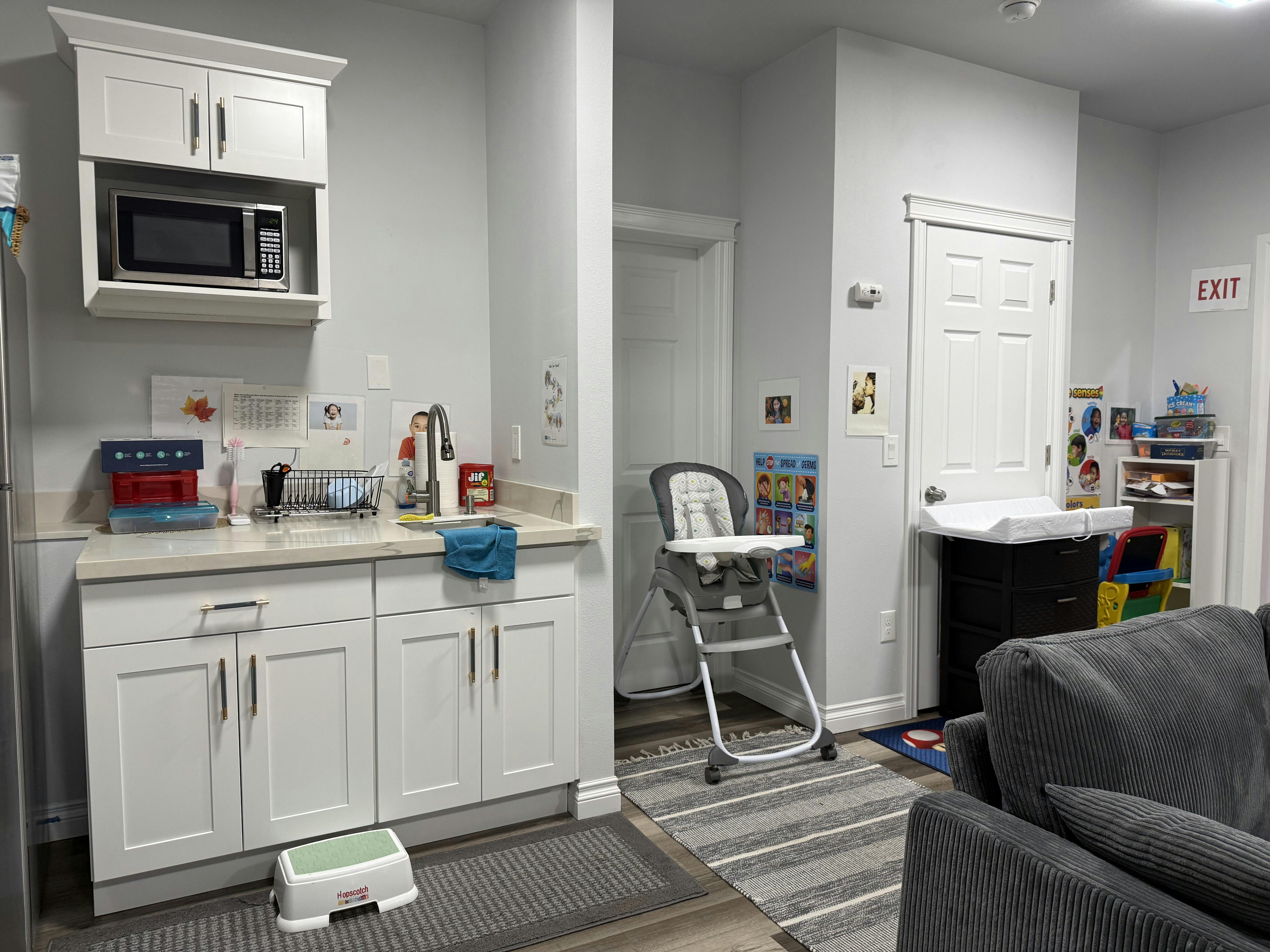 Baby changing station and kitchen area with microwave and sink