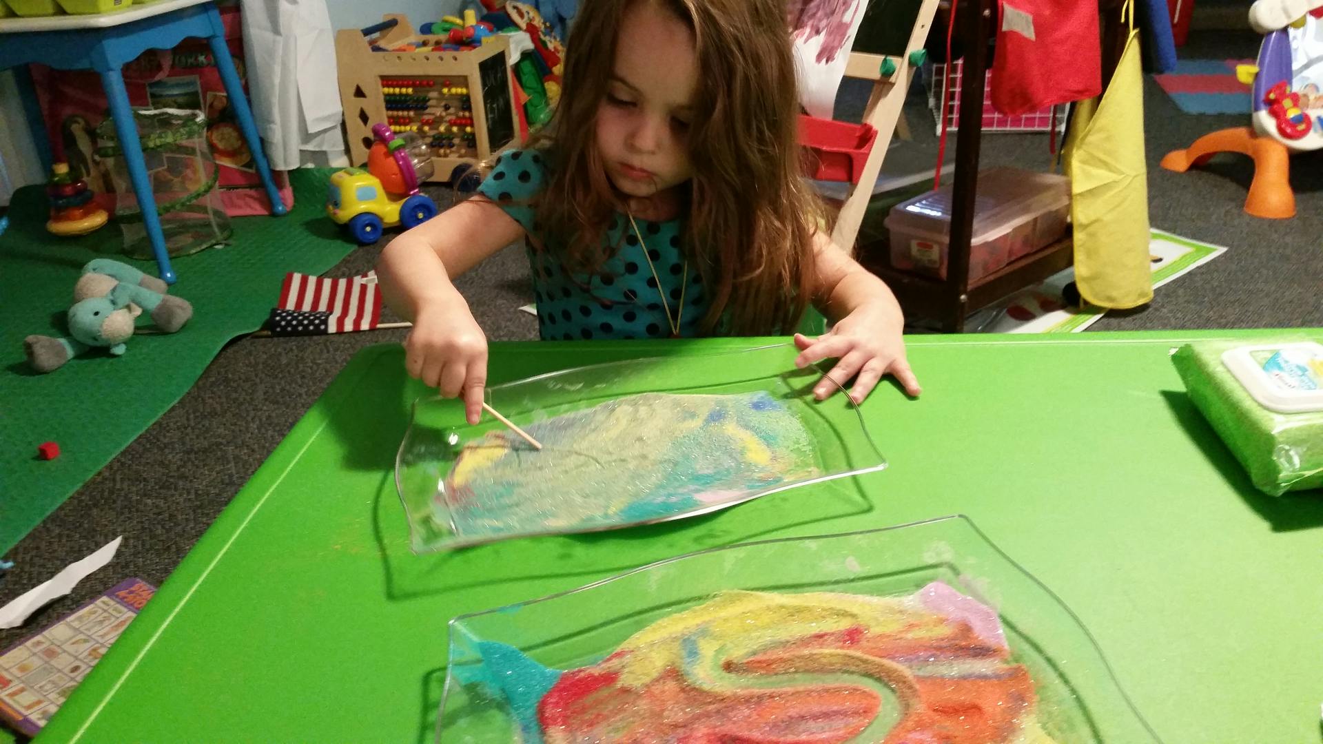 Child painting on a clear surface