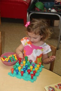 Child playing with a pegboard toy