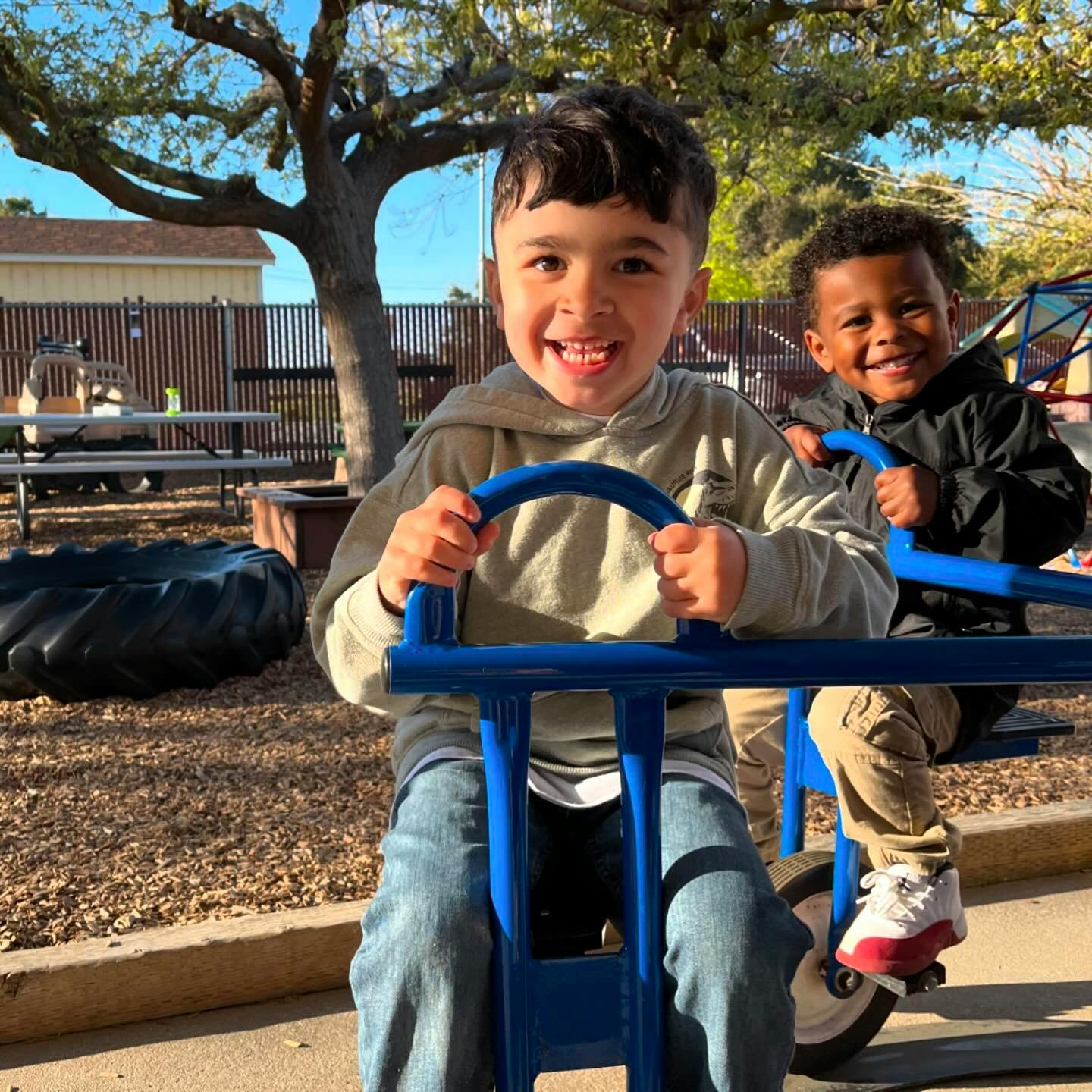 Two children on a blue tandem tricycle