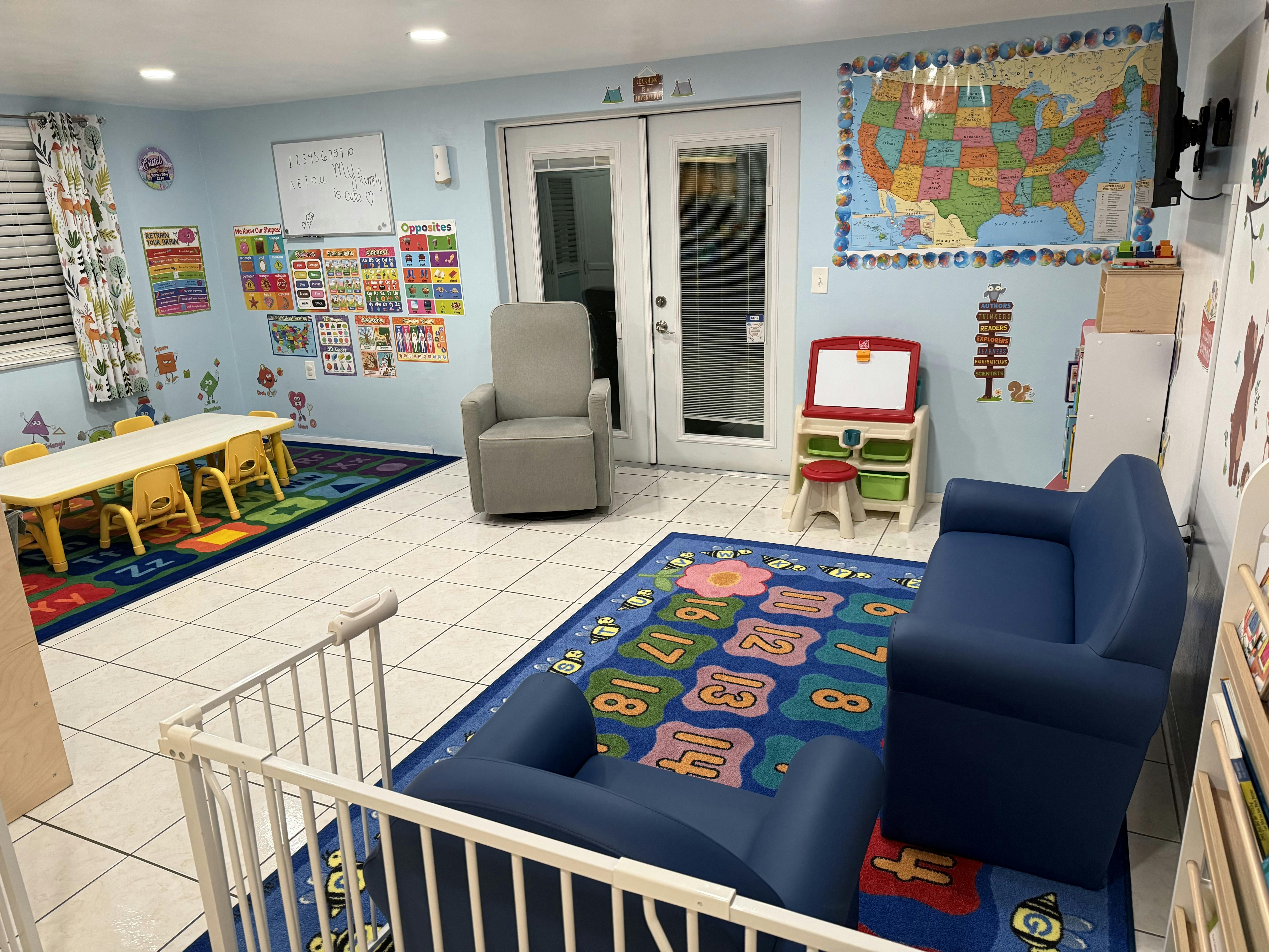 Playroom with small tables, chairs, rugs, and a map on the wall