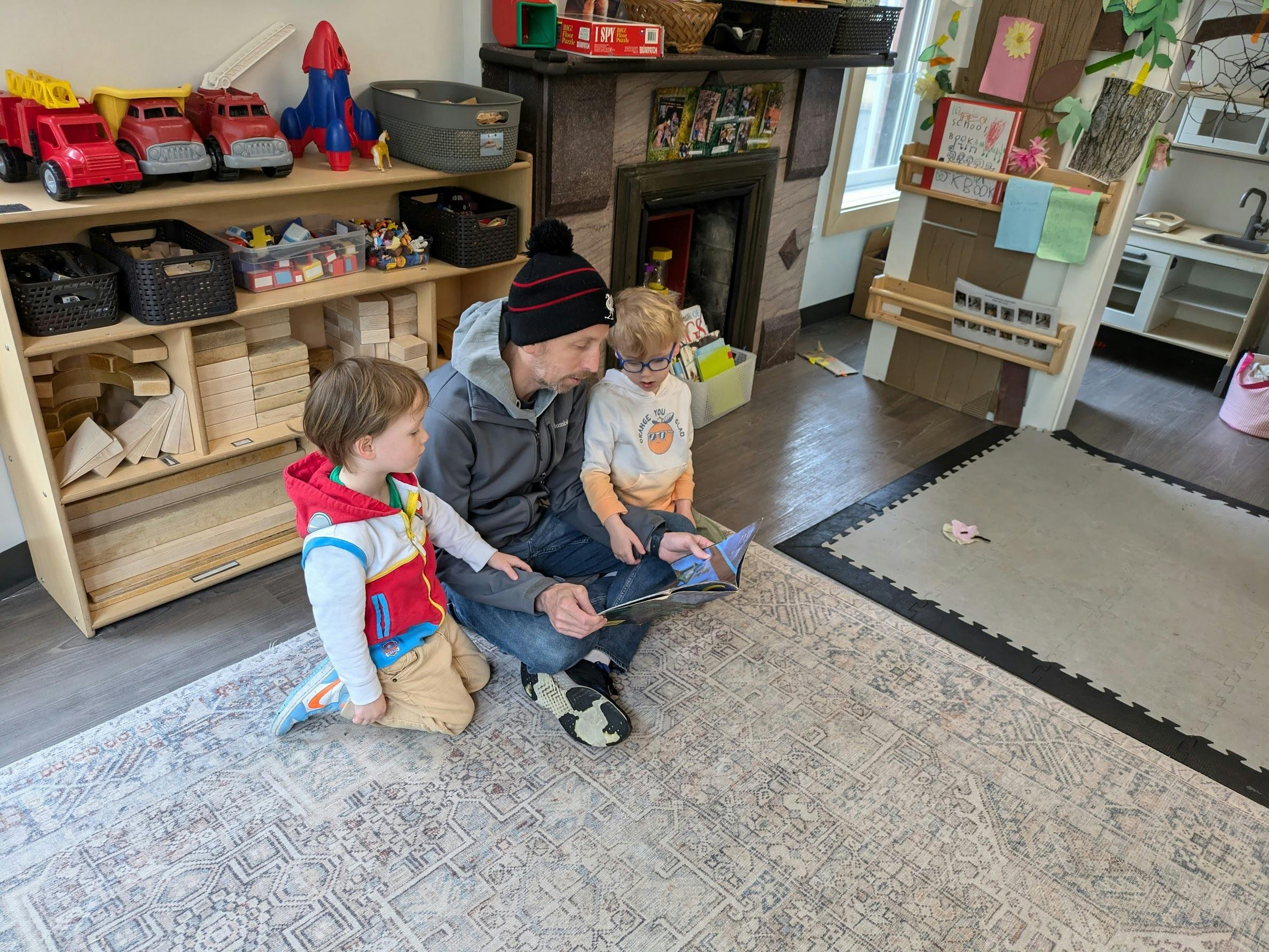 Person reading a book to two children